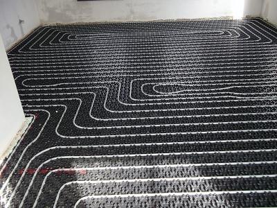 De vloerverwarming op noppenplaat met de slangen in een slakkenhuispatroon.