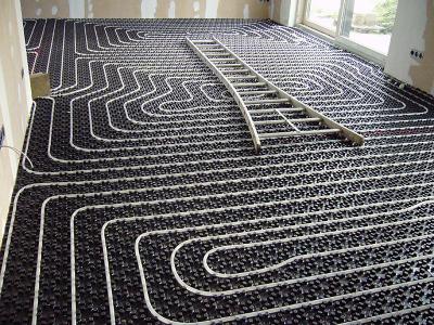 De vloerverwarming op noppenplaat met de slangen in een slakkenhuispatroon.