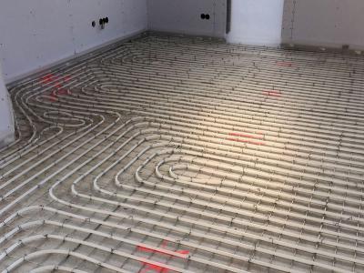 De vloerverwarming wordt in een slakkenhuispatroon gemonteerd op een isolerende tackerplaat.