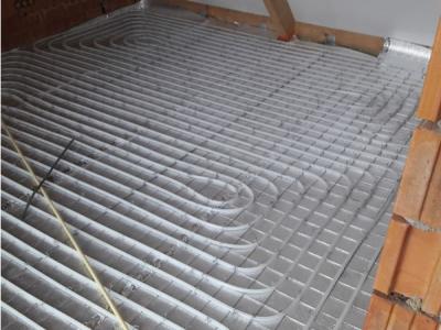 De leidingen van de vloerverwarming worden gemonteerd op een isolerende tackerplaat.