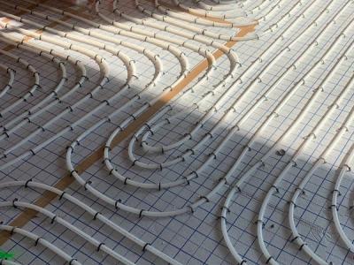 De vloerverwarming op tackerplaat, in slakkenhuispatroon voor een goede warmtespreiding.
