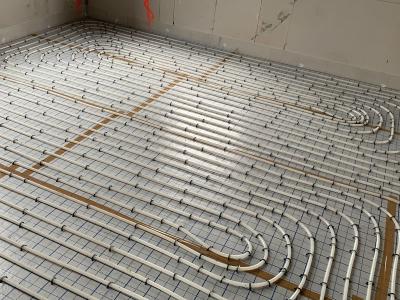 De vloerverwarming, slakkenhuispatroon op isolerende tackerplaat.